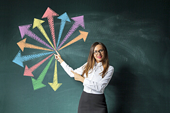 junge Frau an Tafel mit bunten Pfeilen darauf