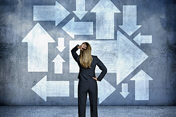 Junge Frau steht vor einer Wand, auf der viele Pfeile zu sehen sind