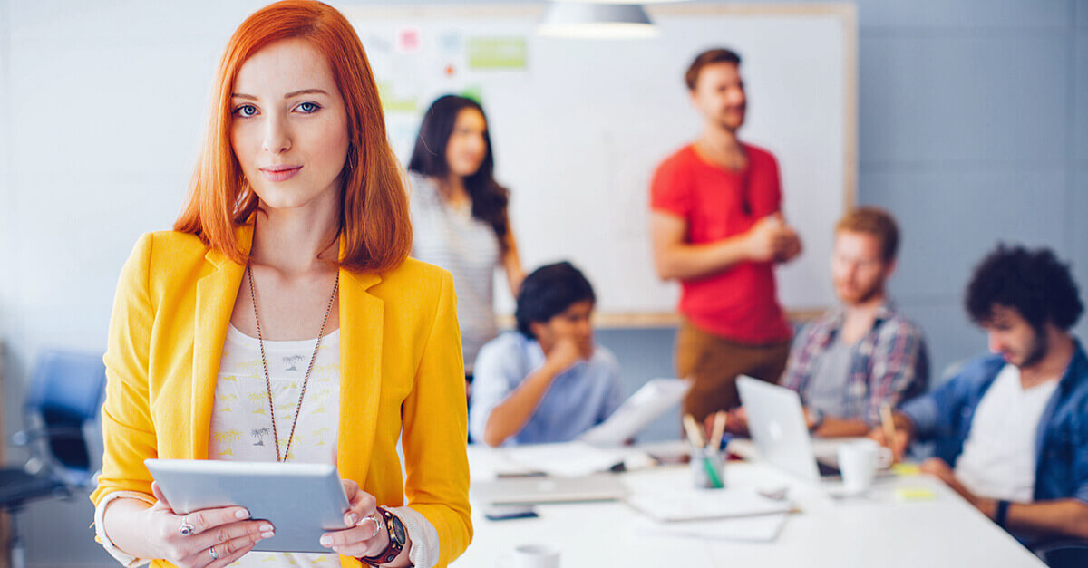 junge Frau mit roten Haaren, steht in einem Konferenzraum