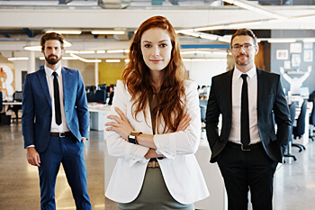 eine junge Frau steht zwischen ihren beiden Kollegen und posiert für ein Foto