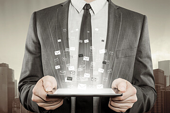 Mann im Anzug hält ein Tablet in der Hand, auf dem eine dreidimensionale Grafik zu sehen ist