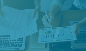 Zwei Finanzmanagerinnen kontrollieren die aktuellen Finanzzahlen mit Tablet und ausgedruckten Listen