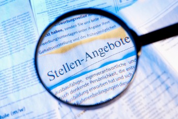 Zeitungsausschnitt, Fokus mit einer Lupe auf Stellenangeboten